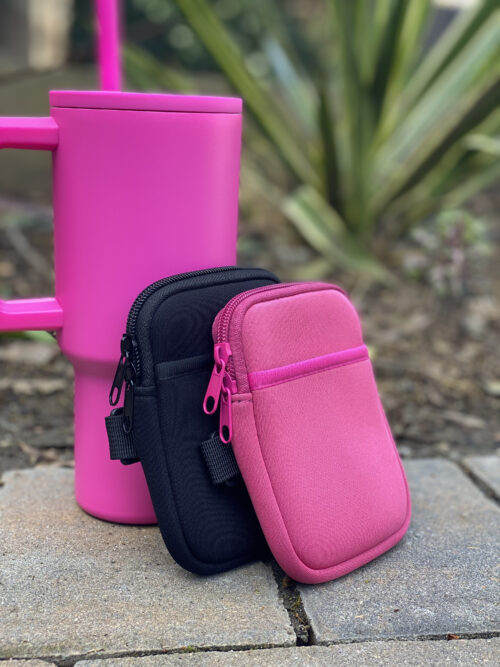 Black and pink pouches next to pink tumbler